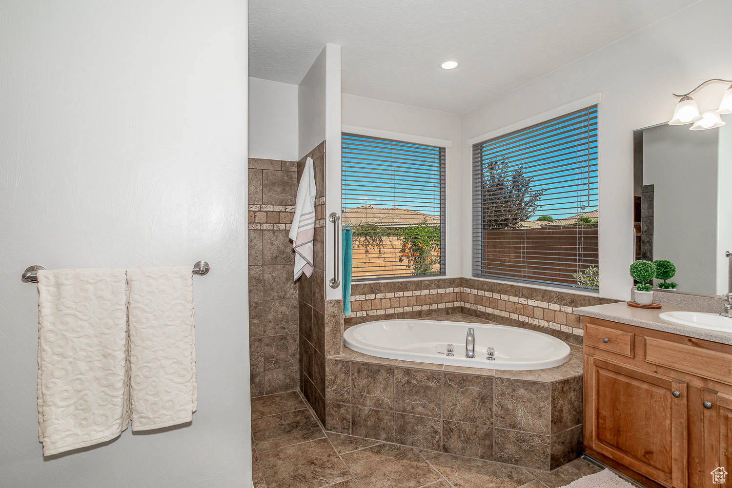 Bathroom with vanity, a relaxing tiled tub, and tile patterned floors