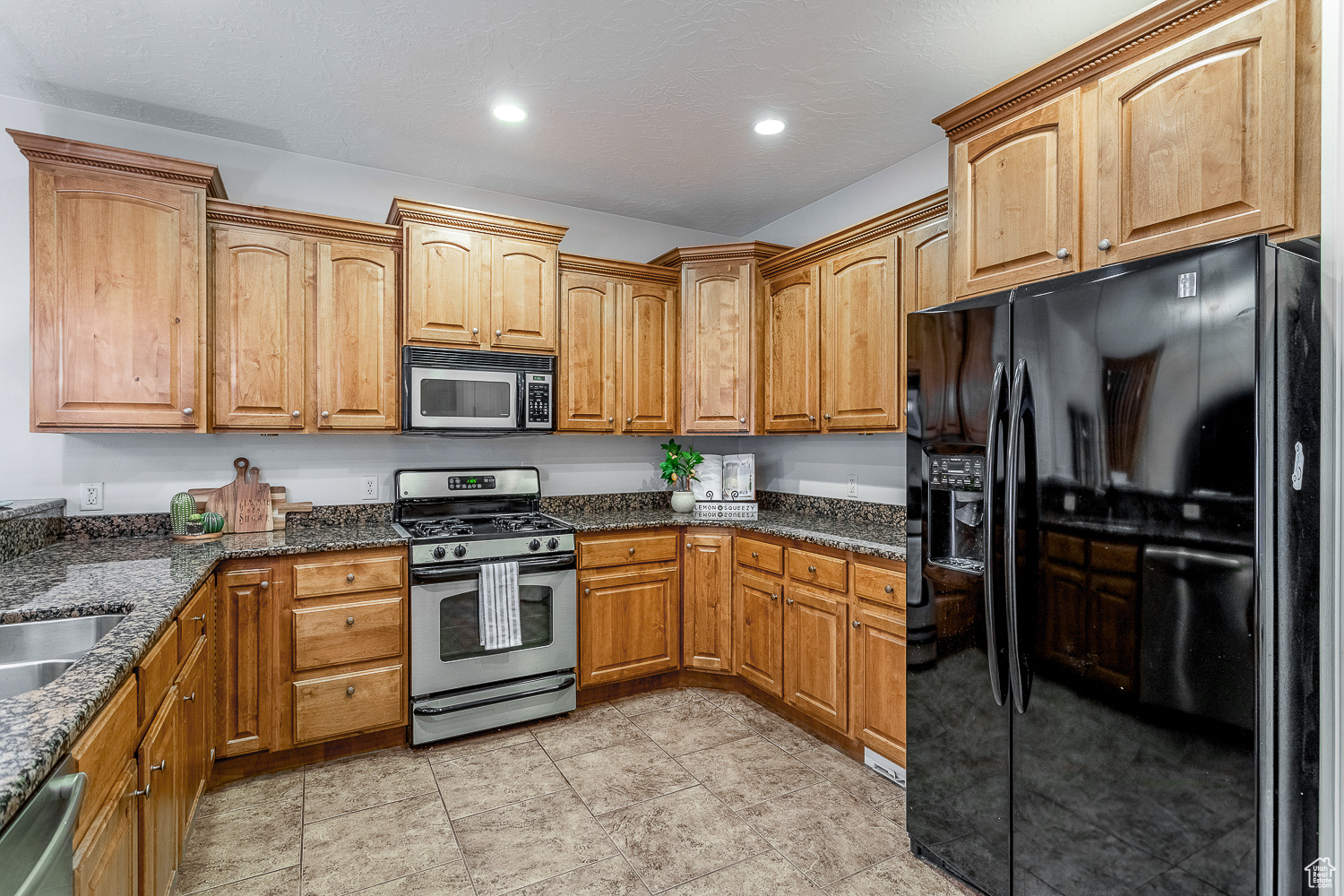 Kitchen featuring dark stone counters and stainless steel appliances