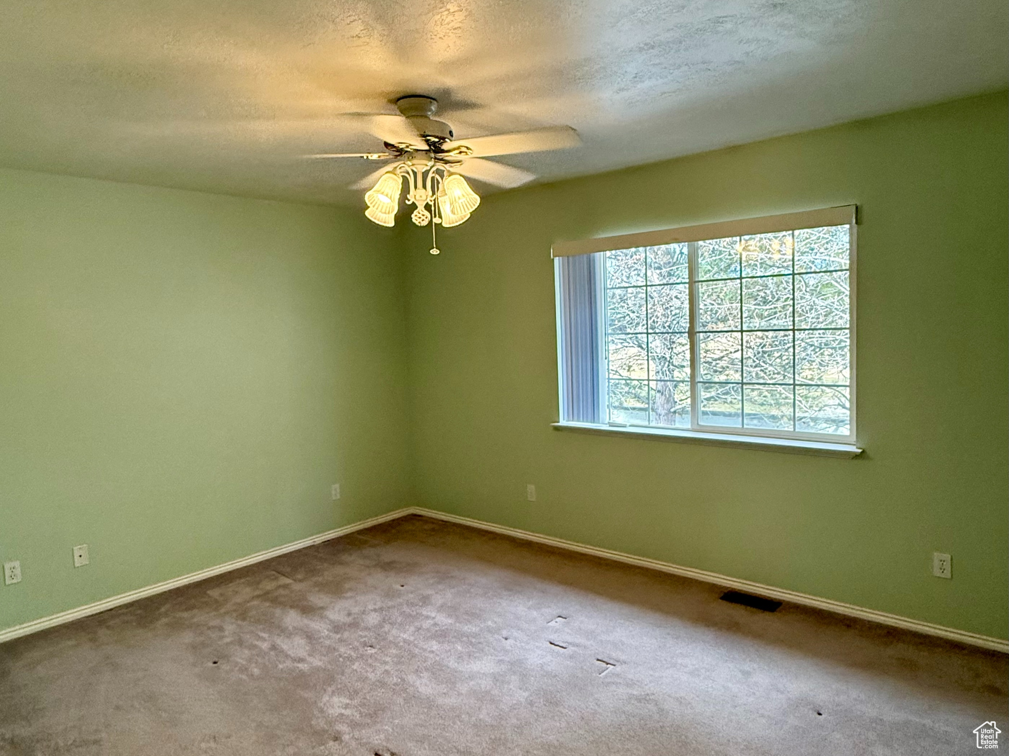 Unfurnished room featuring carpet flooring, a textured ceiling, and ceiling fan