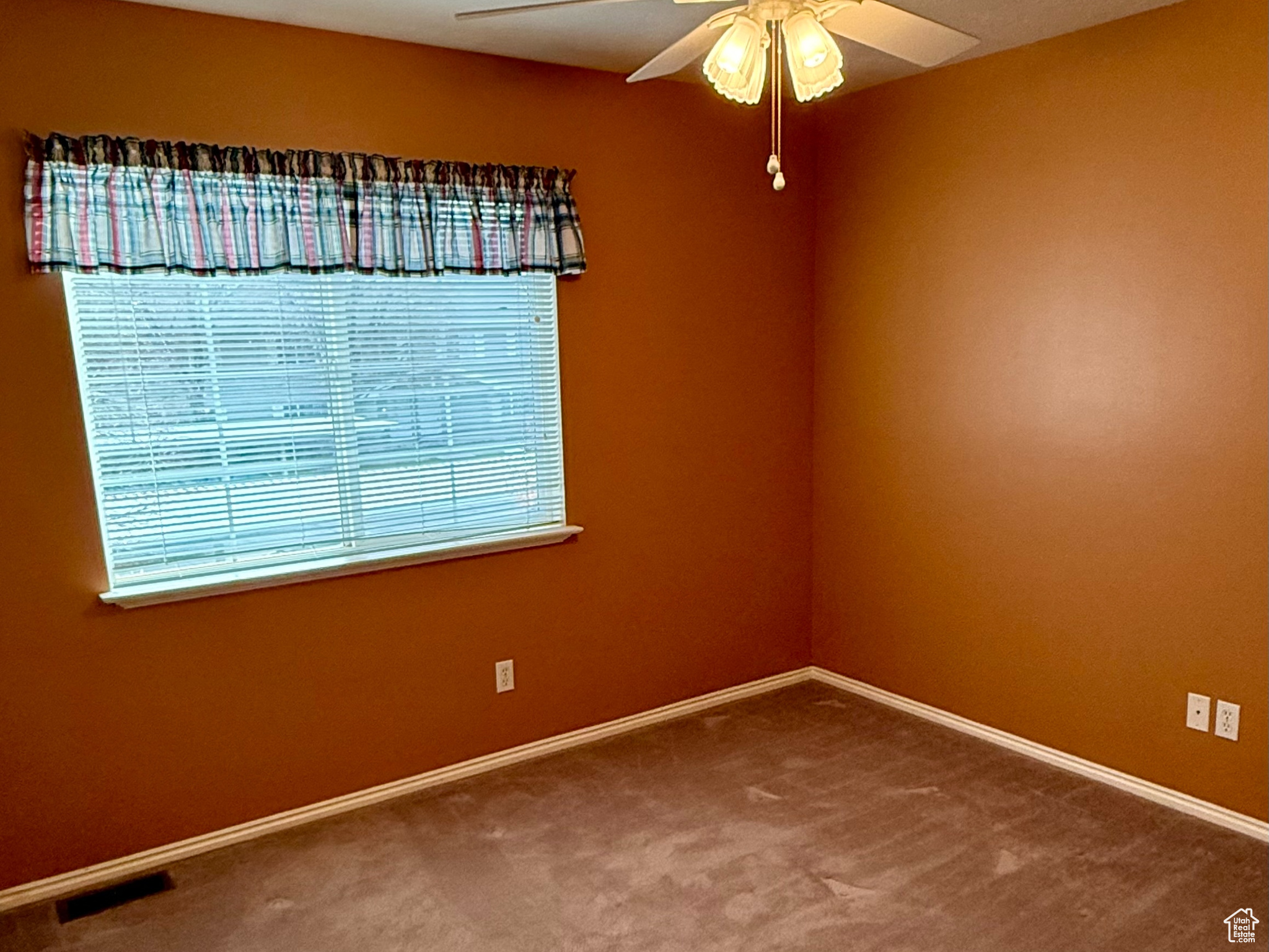 Unfurnished room featuring ceiling fan and carpet floors