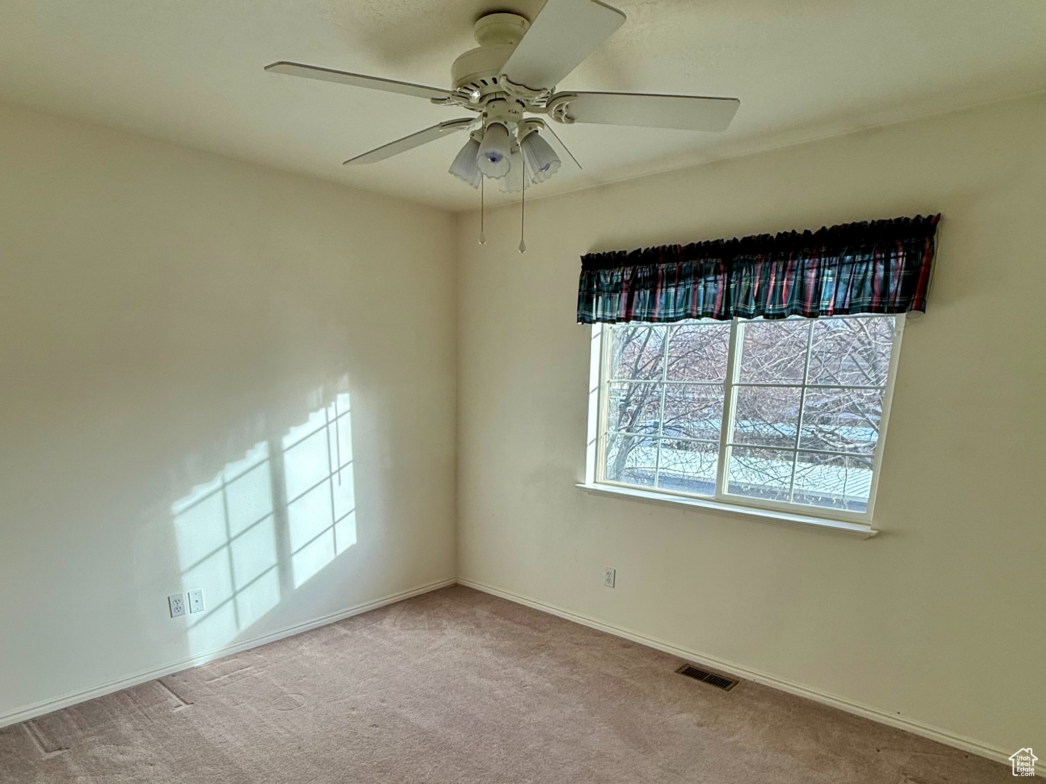 Empty room featuring carpet floors and ceiling fan