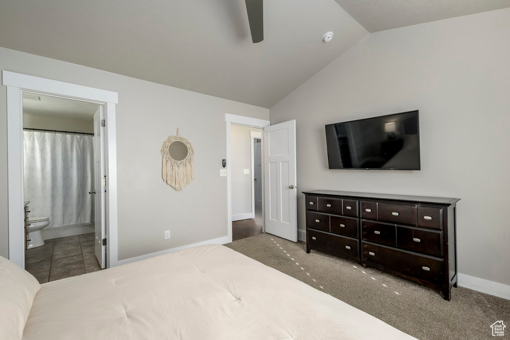 Carpeted bedroom with ensuite bathroom, ceiling fan, and vaulted ceiling