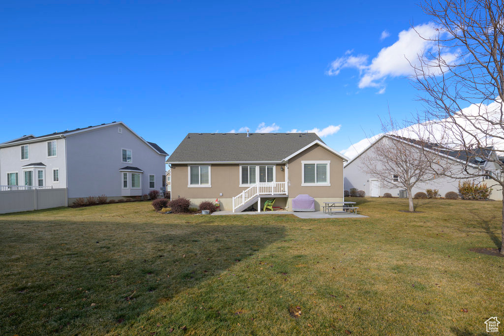 Back of house with a yard