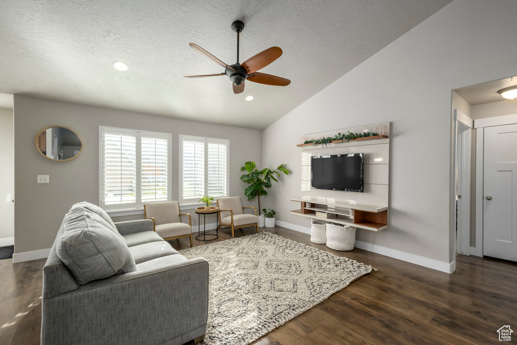 Living room featuring ceiling fan, dark hardwood / wood-style floors, a textured ceiling, and vaulted ceiling