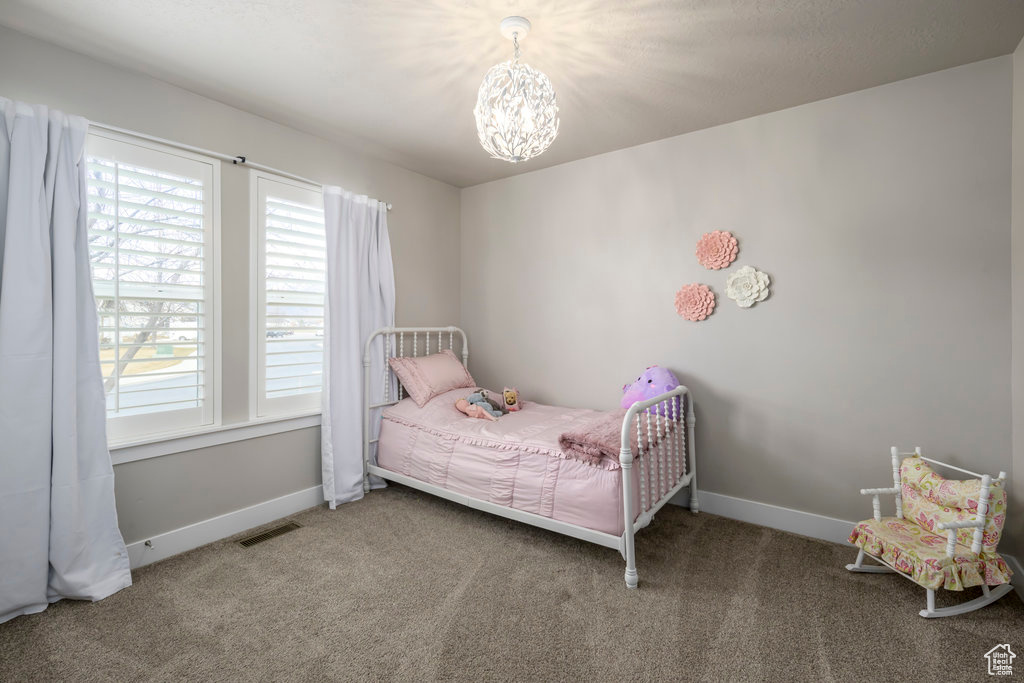 Bedroom featuring carpet floors and a notable chandelier