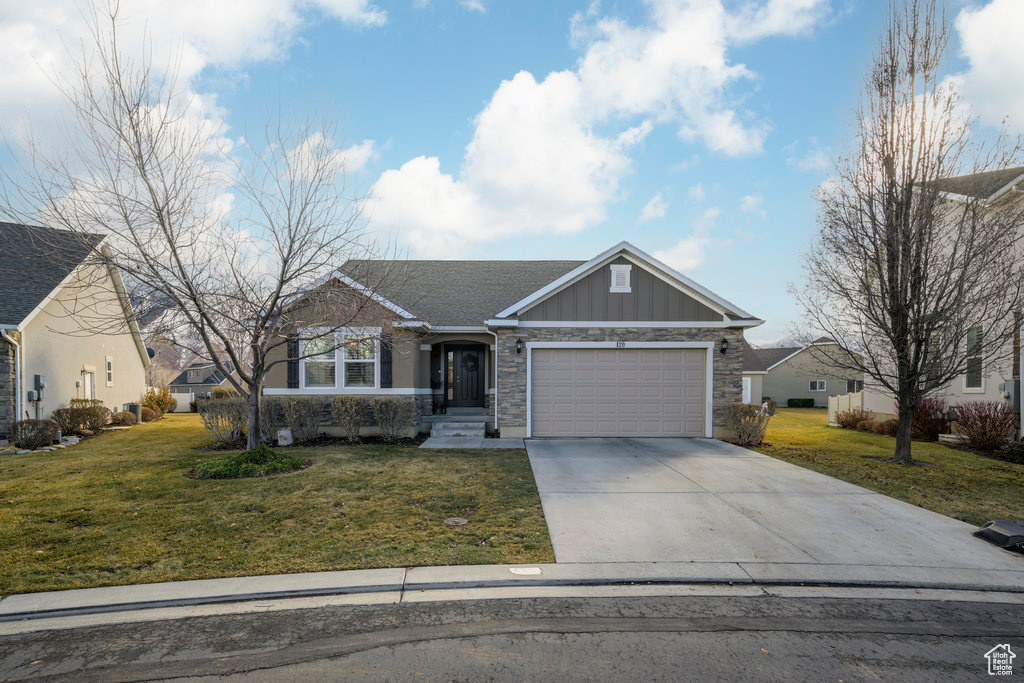 View of front of home with a front yard and a garage