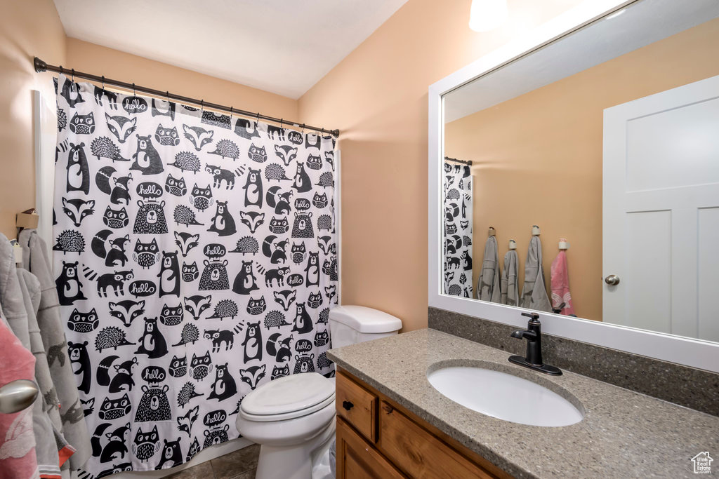 Bathroom with tile patterned floors, vanity, and toilet