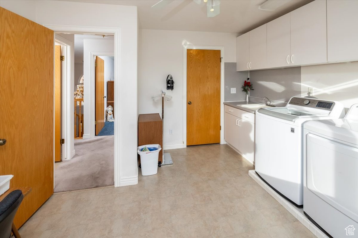 Laundry area / Craft room with ceiling fan, sink, cabinets, and independent washer and dryer