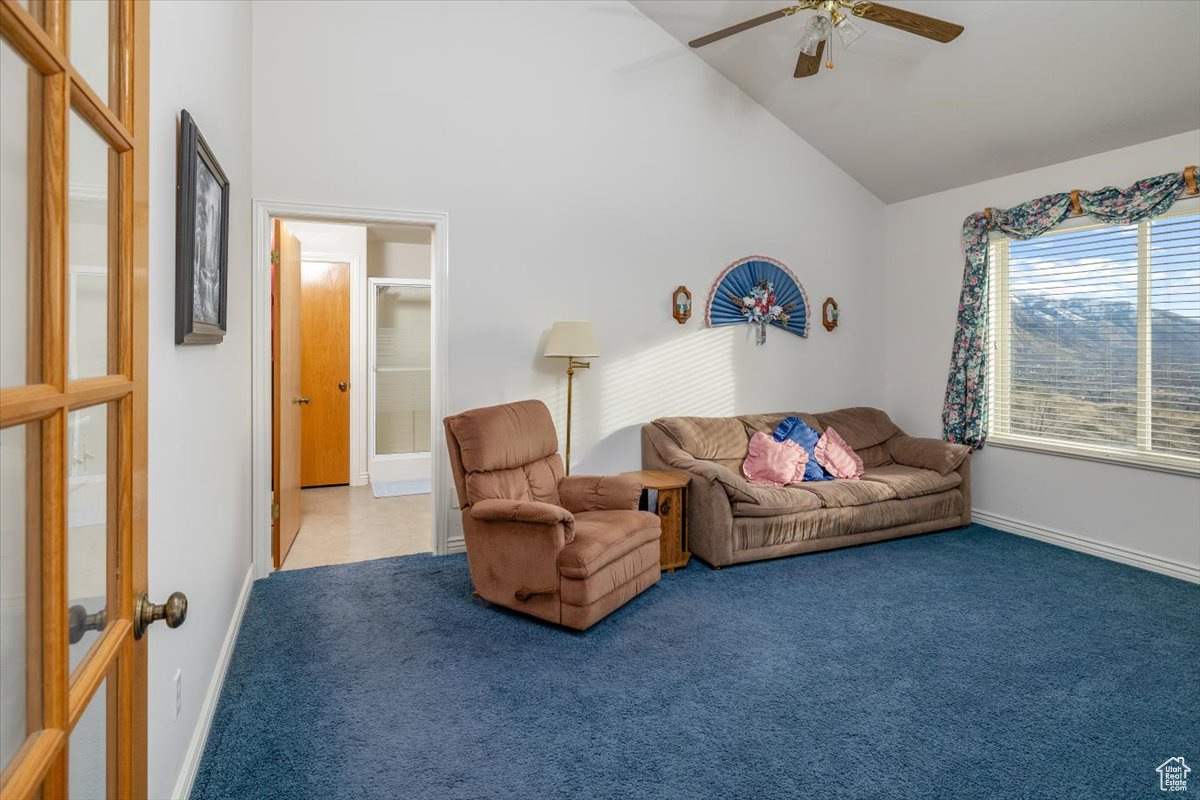 Living room featuring carpet, high vaulted ceiling, and ceiling fan