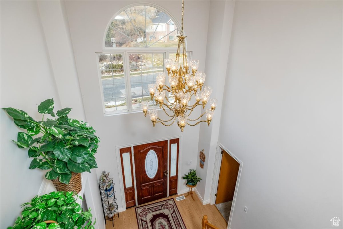 Entryway featuring a high ceiling and light hardwood / wood-style flooring