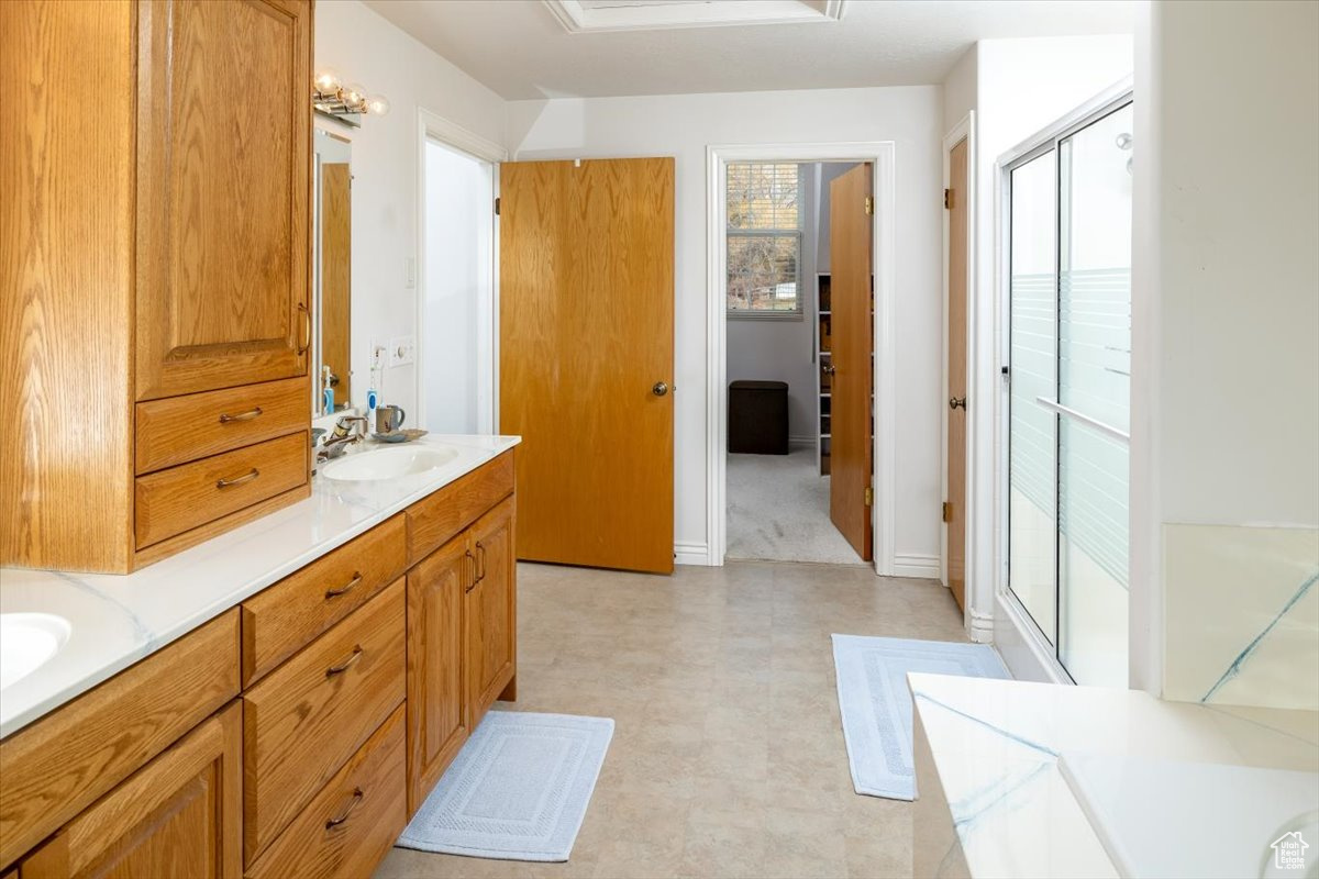 Bathroom featuring vanity and a shower with door