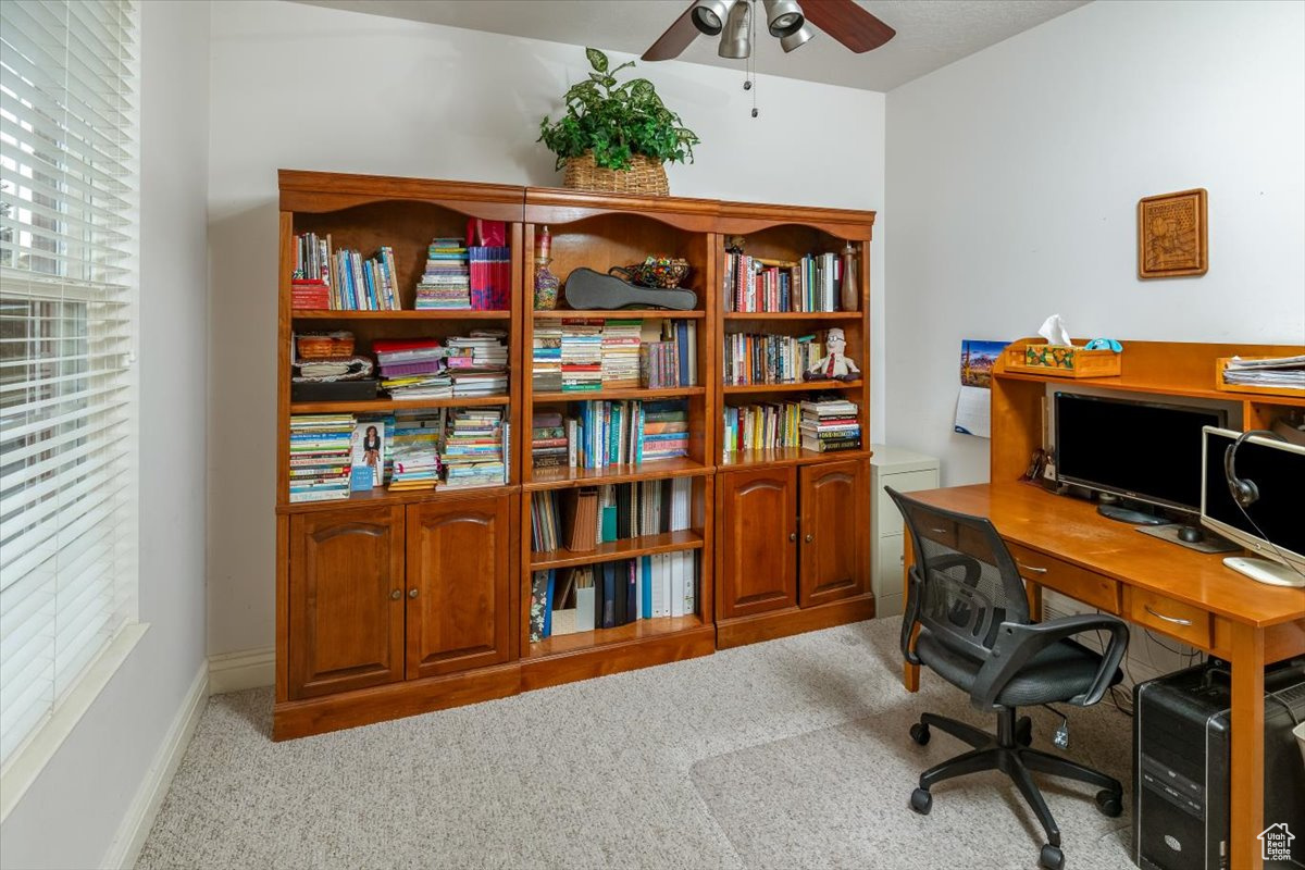 Carpeted office space with ceiling fan could be 6th bedroom