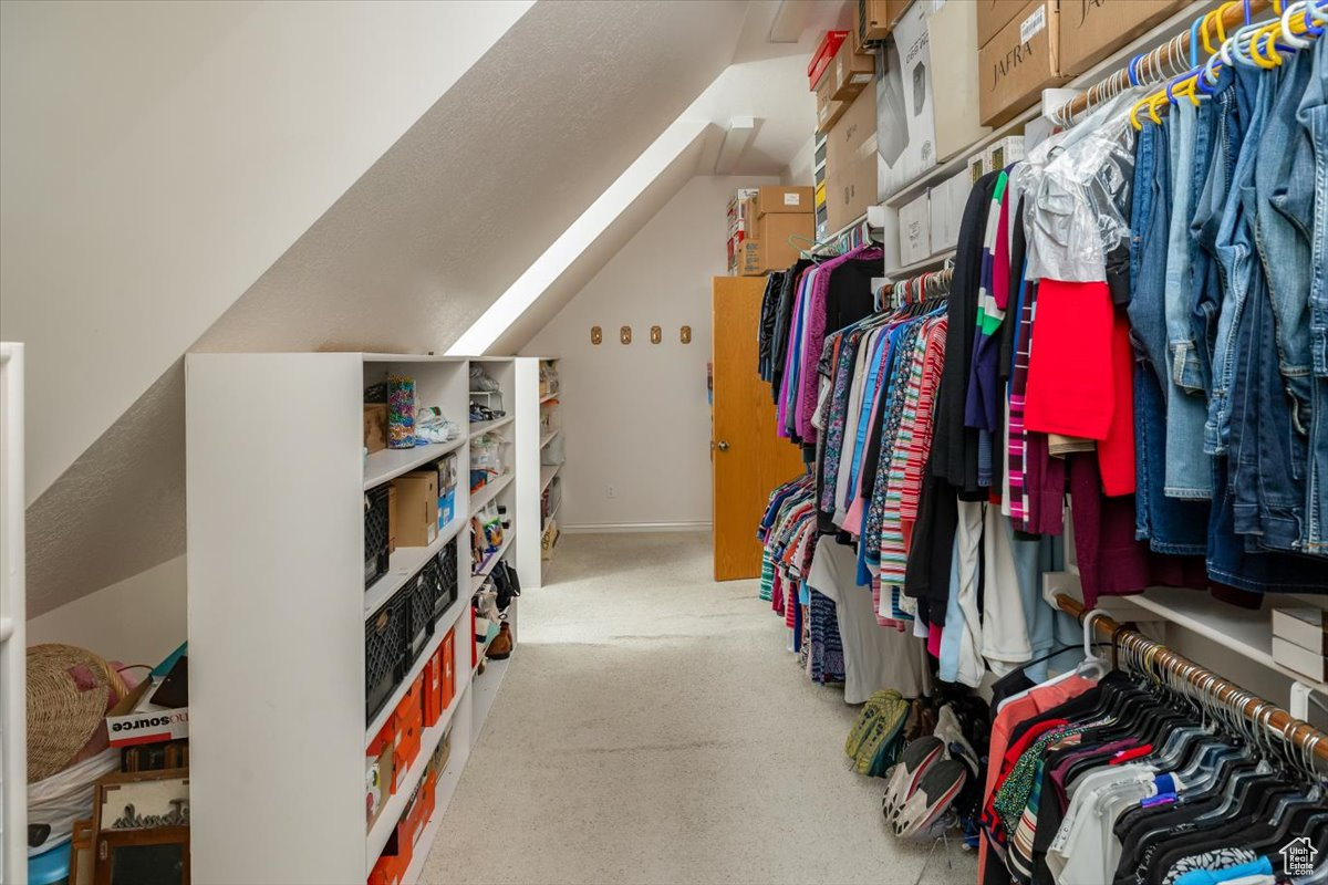 Walk in closet with lofted ceiling. Over top of garage