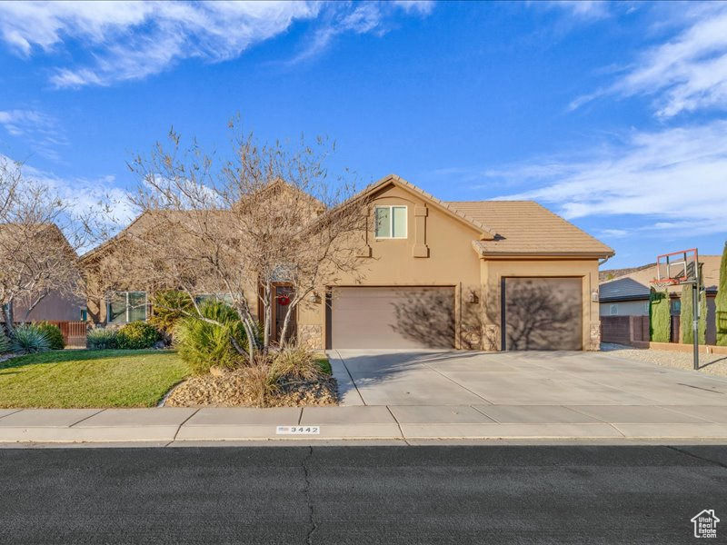 View of front of home featuring a front lawn and a garage