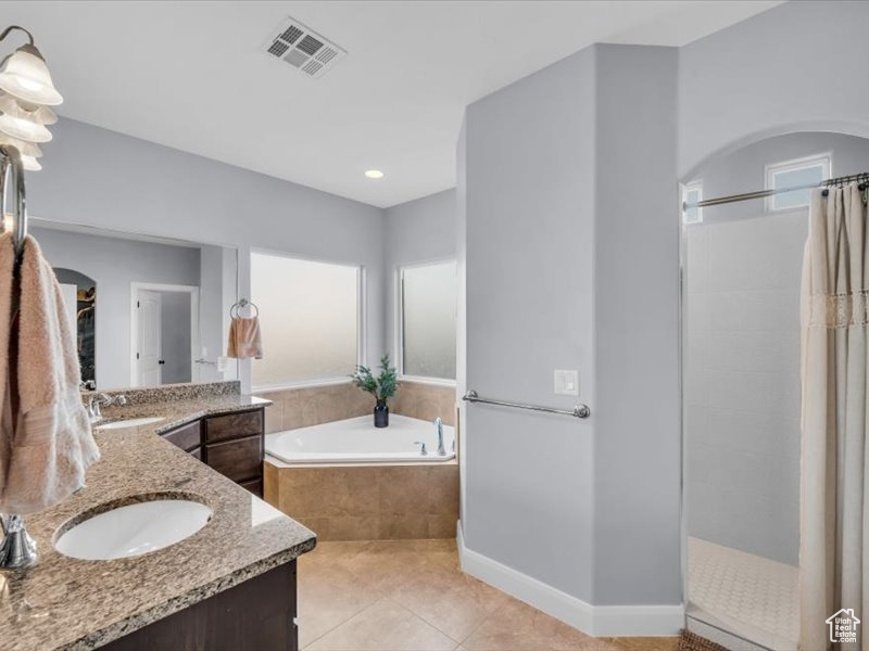 Bathroom with tile patterned flooring, vanity, separate shower and tub, and a healthy amount of sunlight