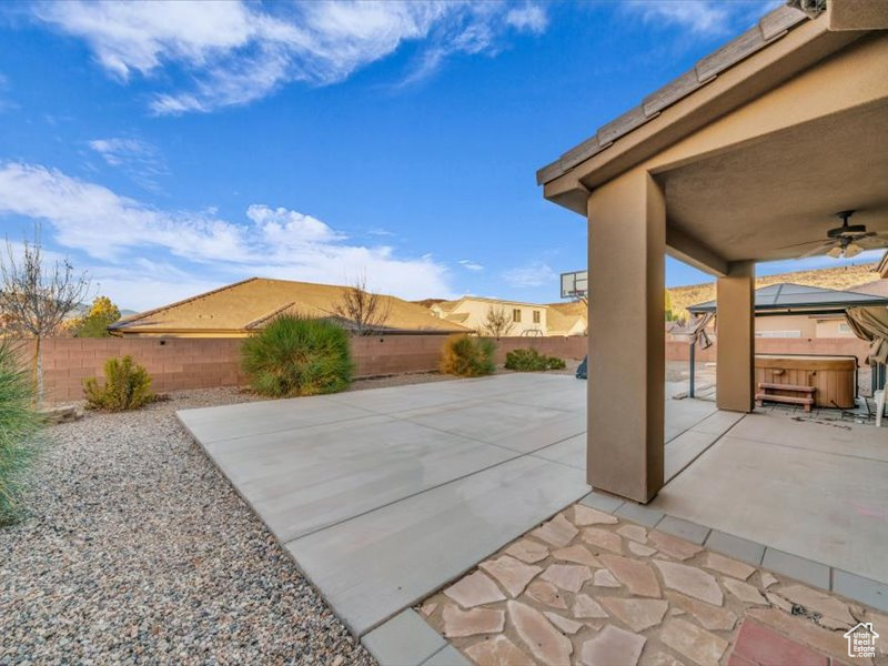 View of patio featuring ceiling fan and a hot tub