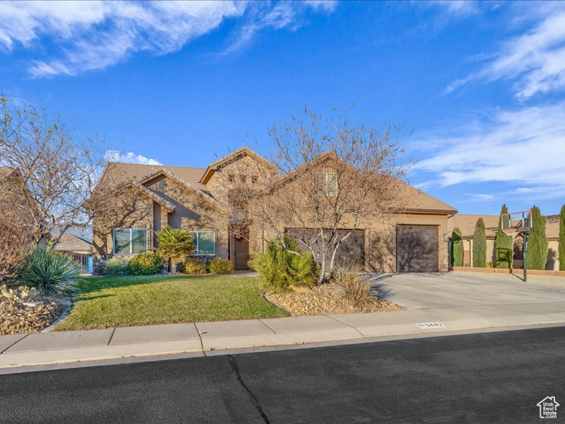 View of front of home featuring a front yard and a garage