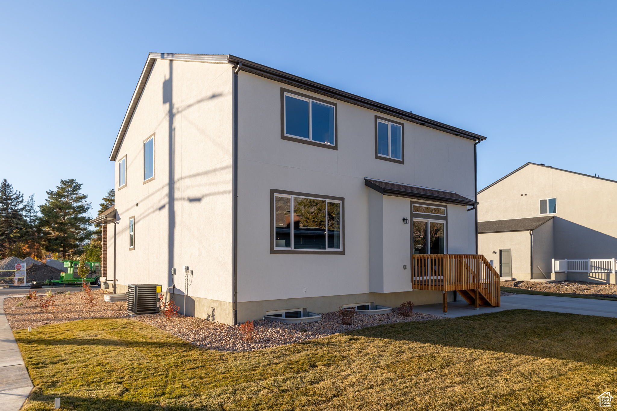 Rear view of house with a lawn and cooling unit