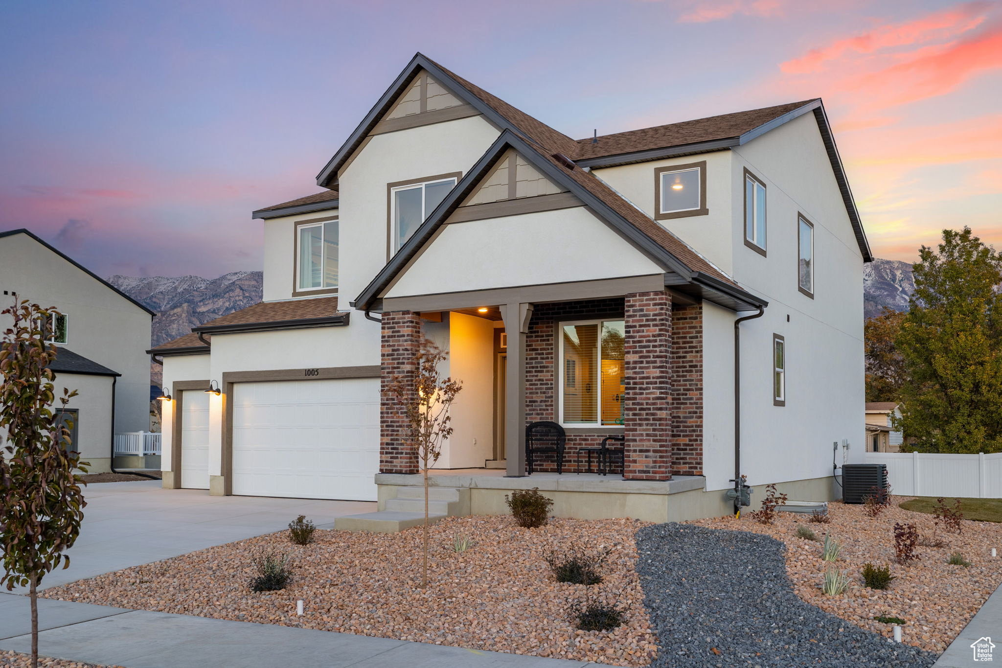 View of front of house featuring a mountain view, cooling unit, covered porch, and a garage