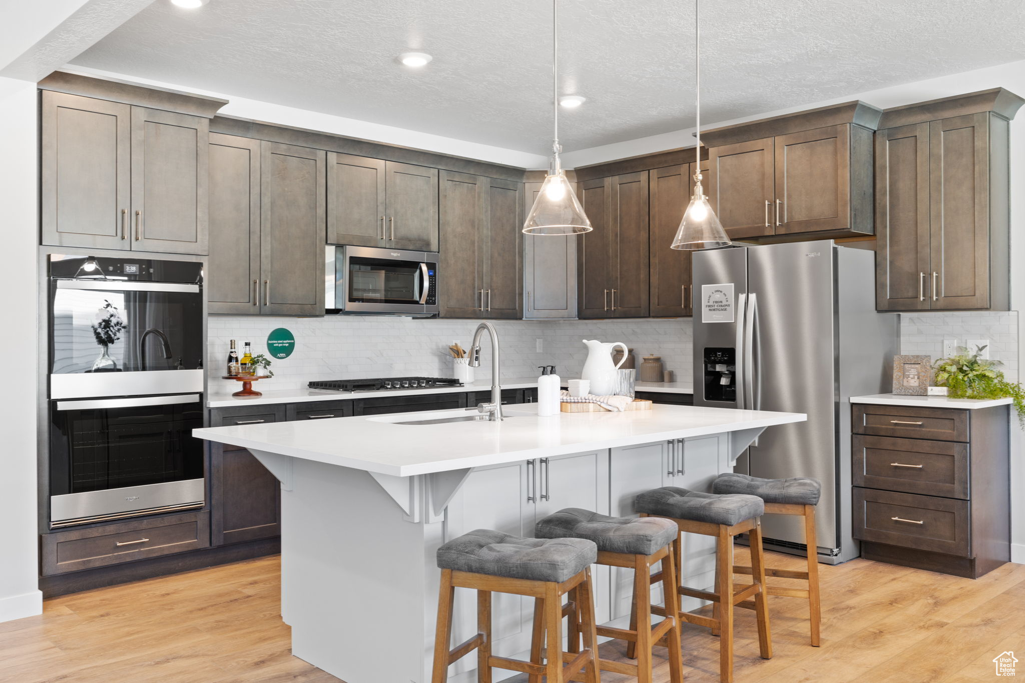 Kitchen featuring a breakfast bar, appliances with stainless steel finishes, sink, and an island with sink