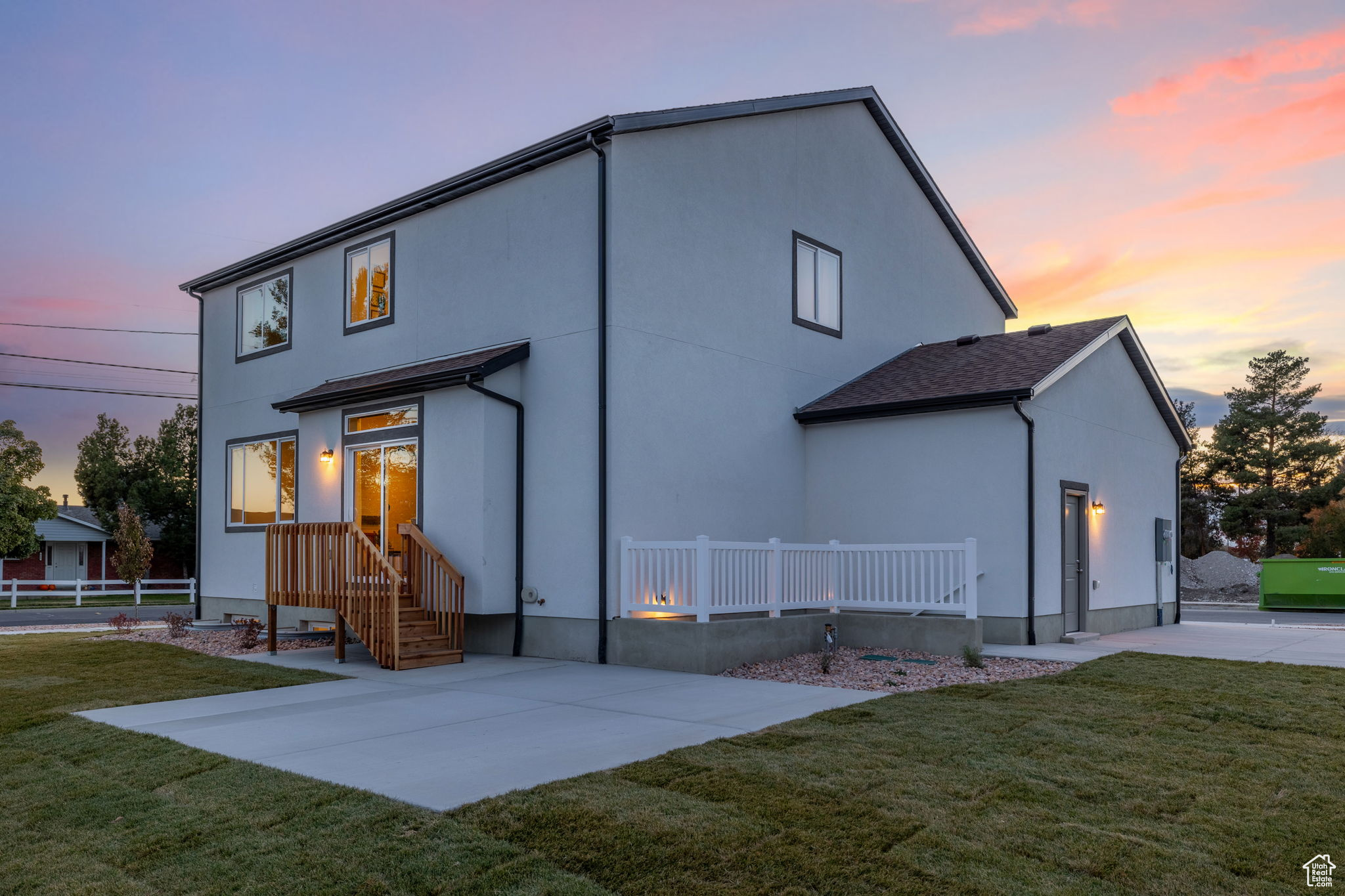 Back house at dusk featuring a yard