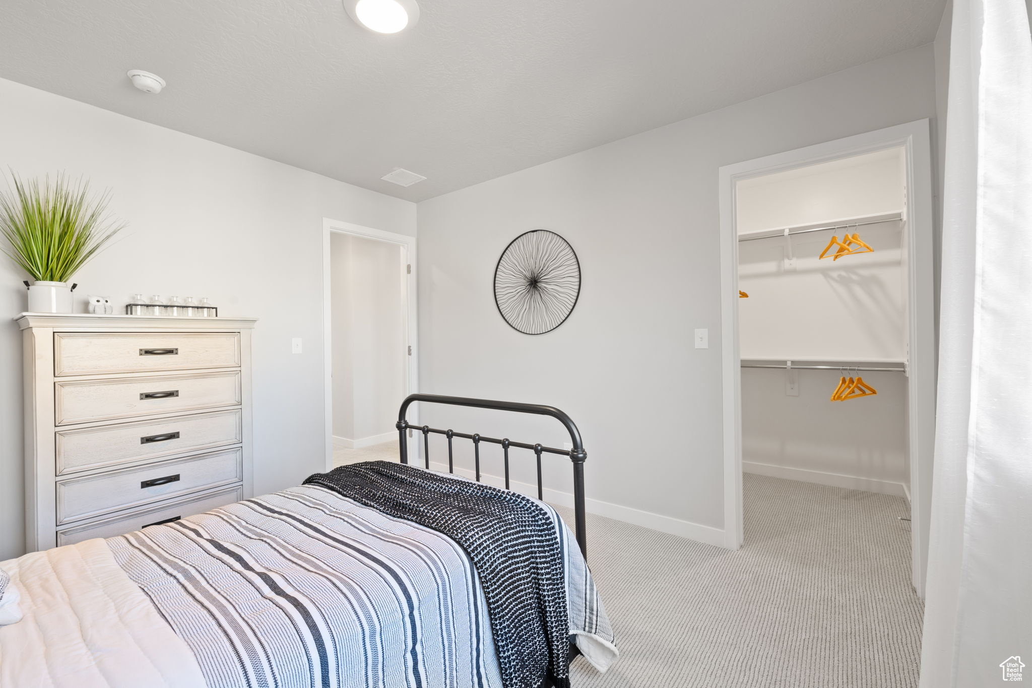 Carpeted bedroom featuring a walk in closet and a closet