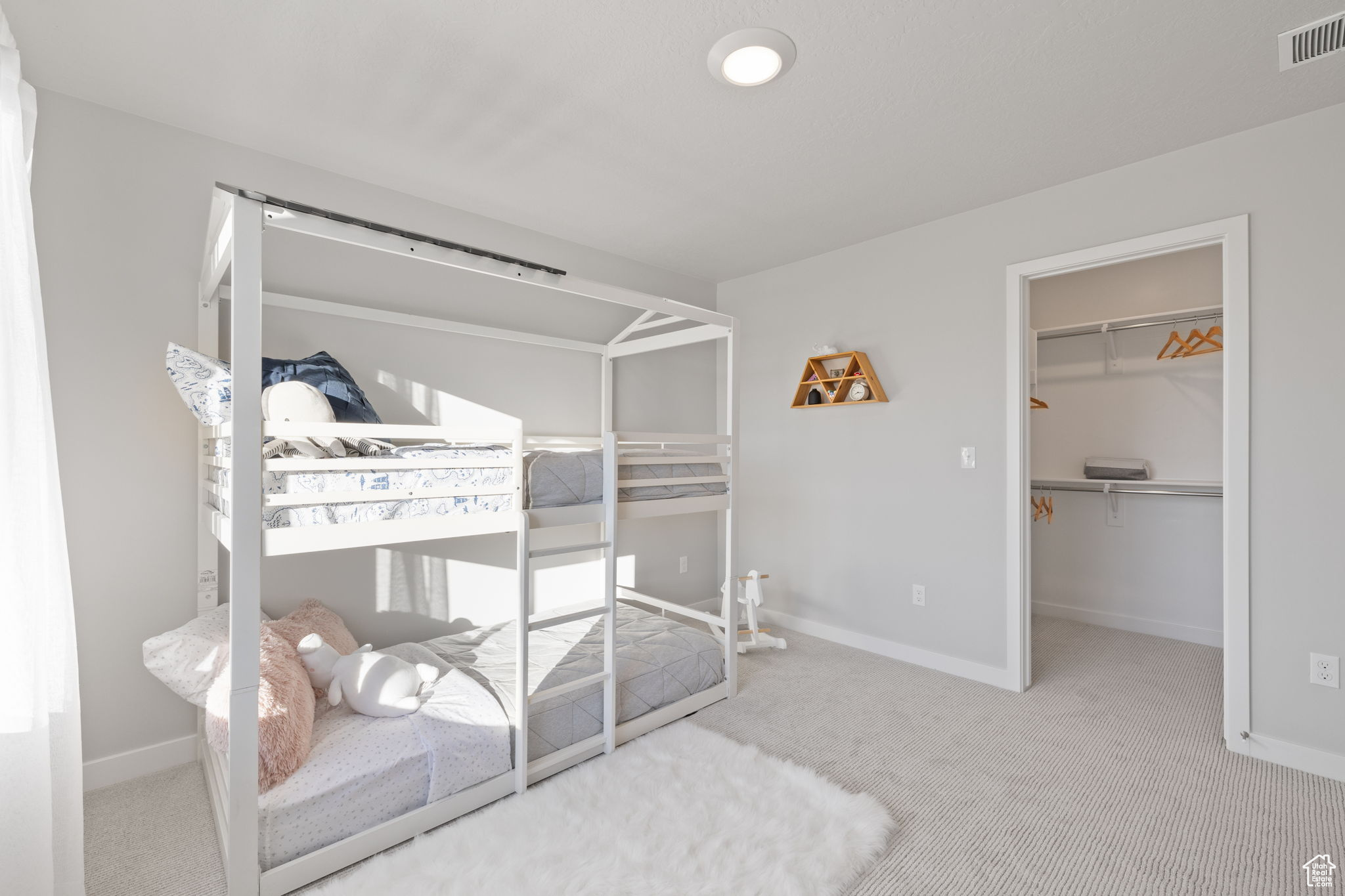 Carpeted bedroom featuring a walk in closet and a closet