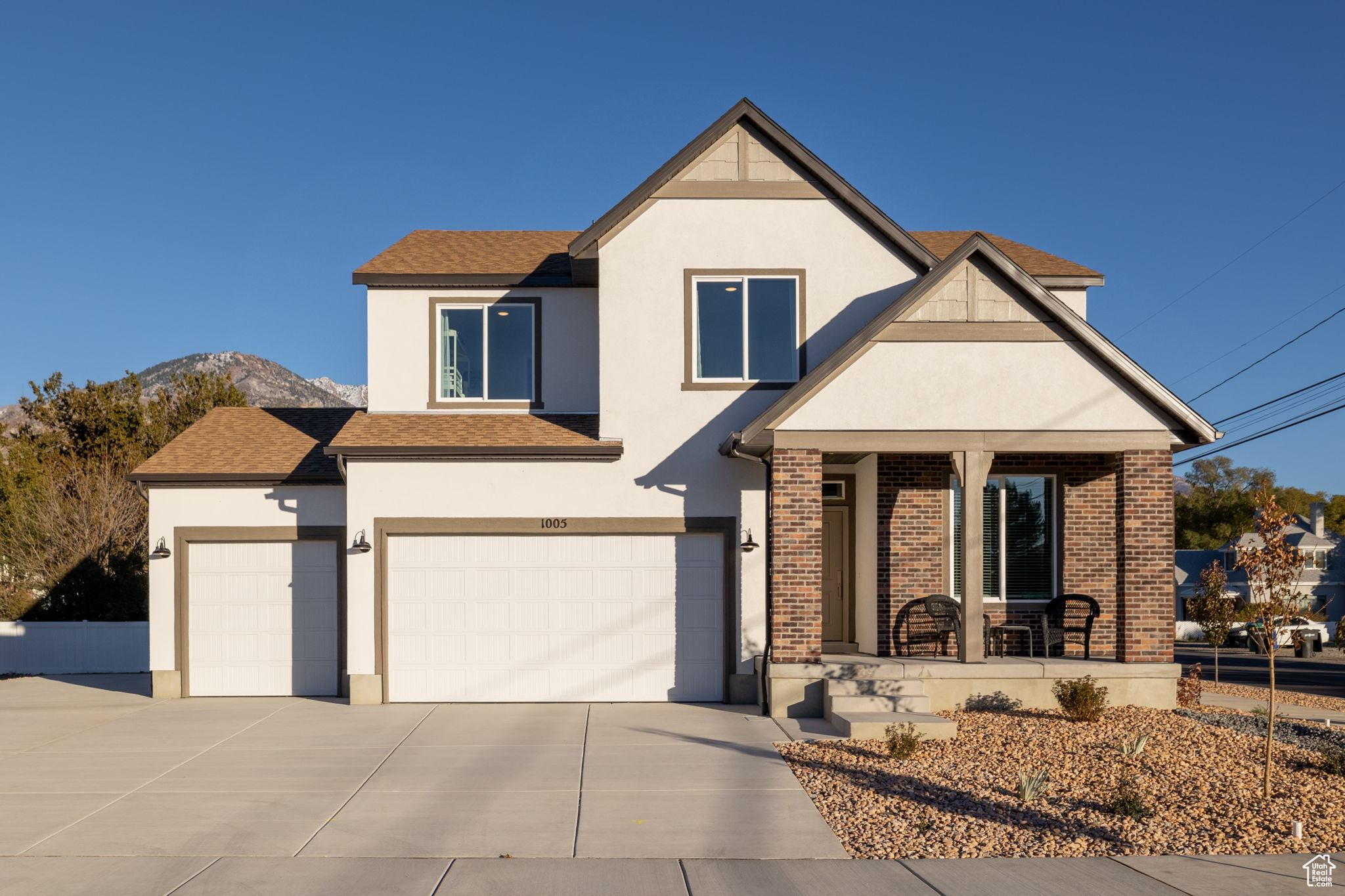 View of front of home featuring a mountain view, a porch, and a garage