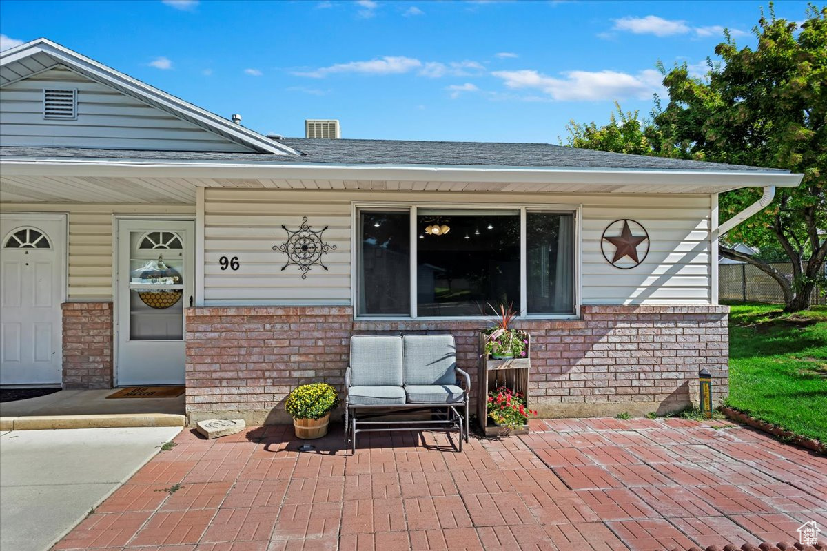 Doorway to property featuring covered porch and a patio