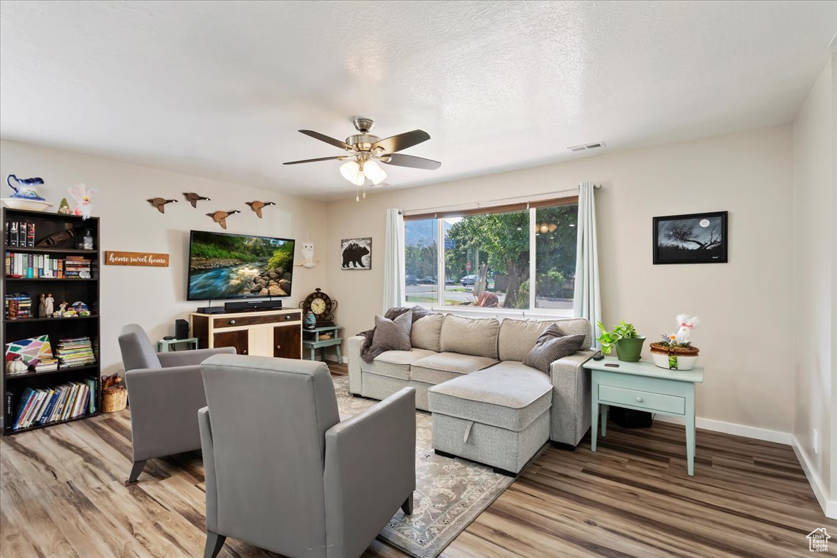 Living room with hardwood / wood-style flooring and ceiling fan