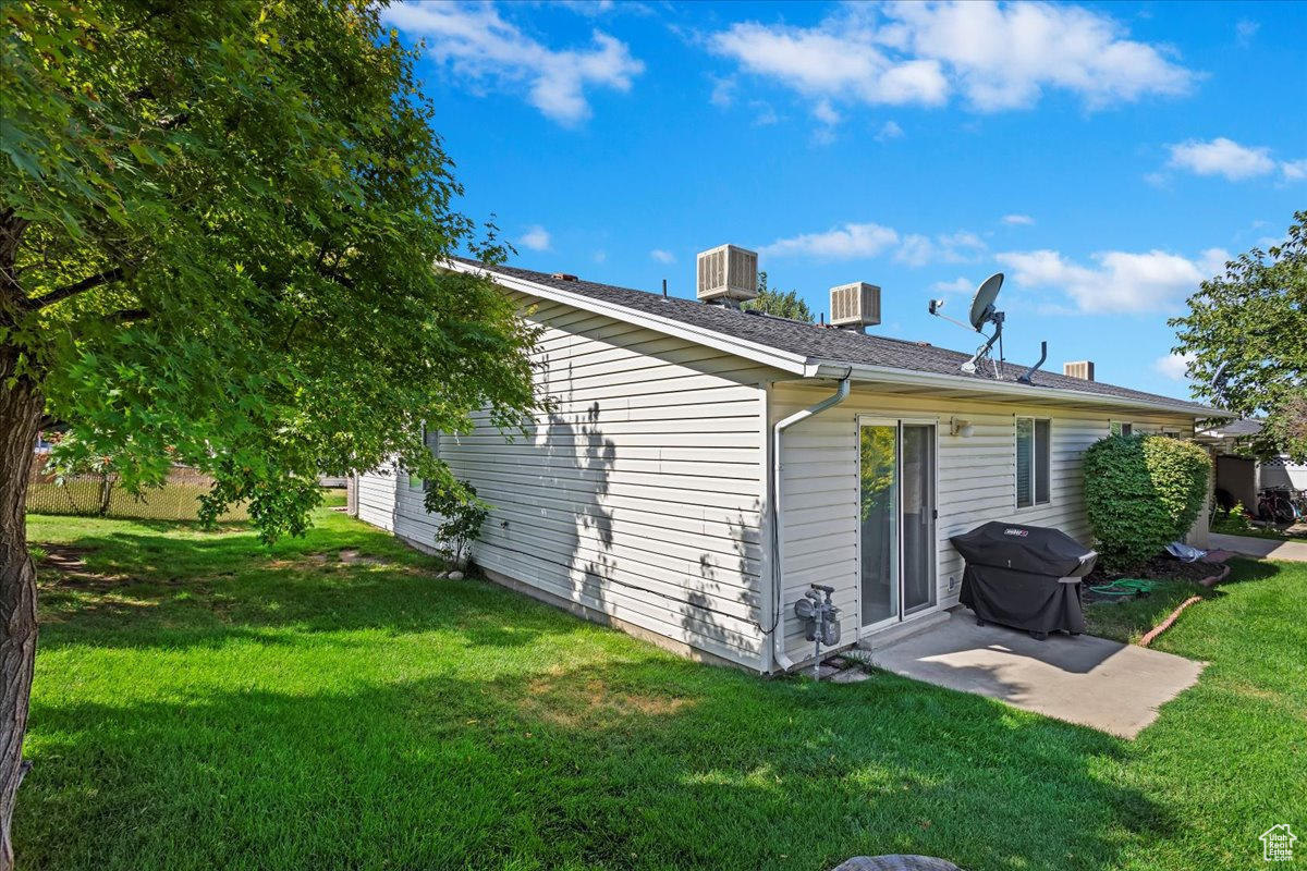 Back of house with a patio area, a yard, and central AC unit