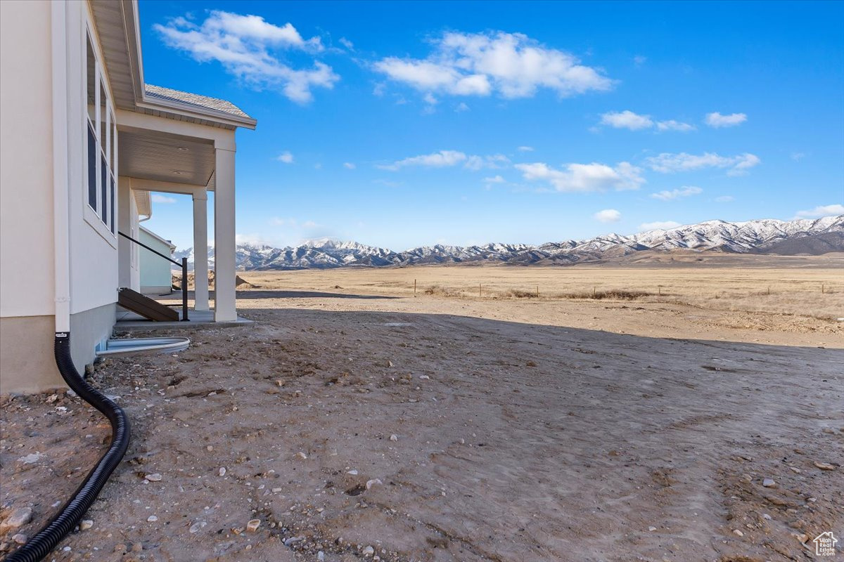 View of yard featuring a mountain view and covered patio