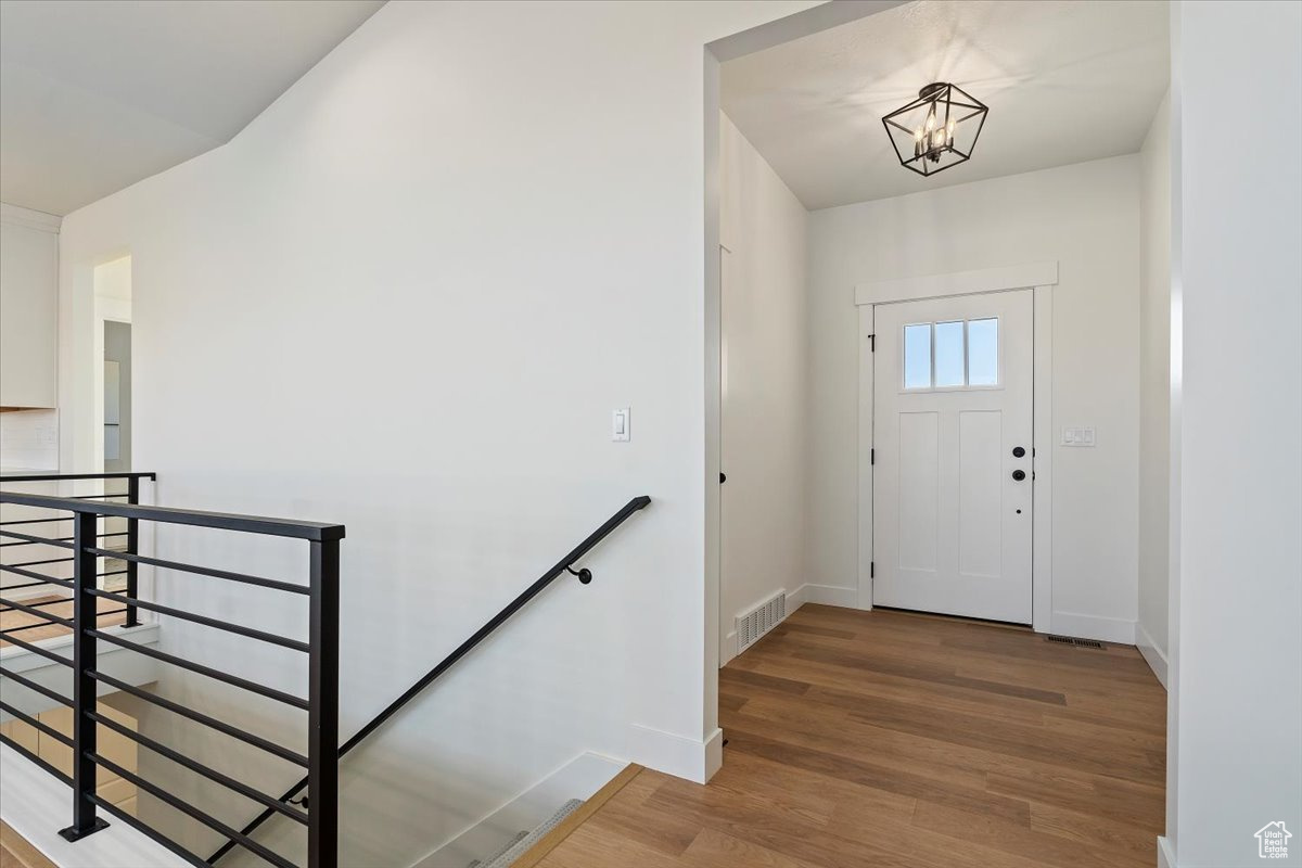 Foyer entrance featuring a chandelier and hardwood / wood-style flooring