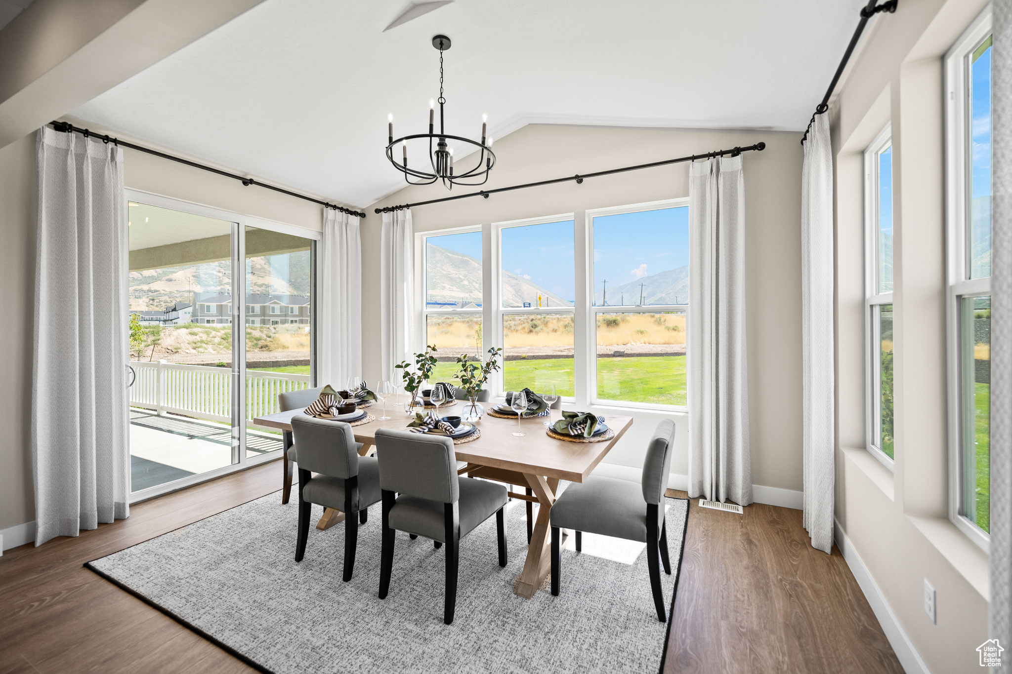 Dining space featuring a mountain view, dark hardwood / wood-style flooring, an inviting chandelier, and vaulted ceiling