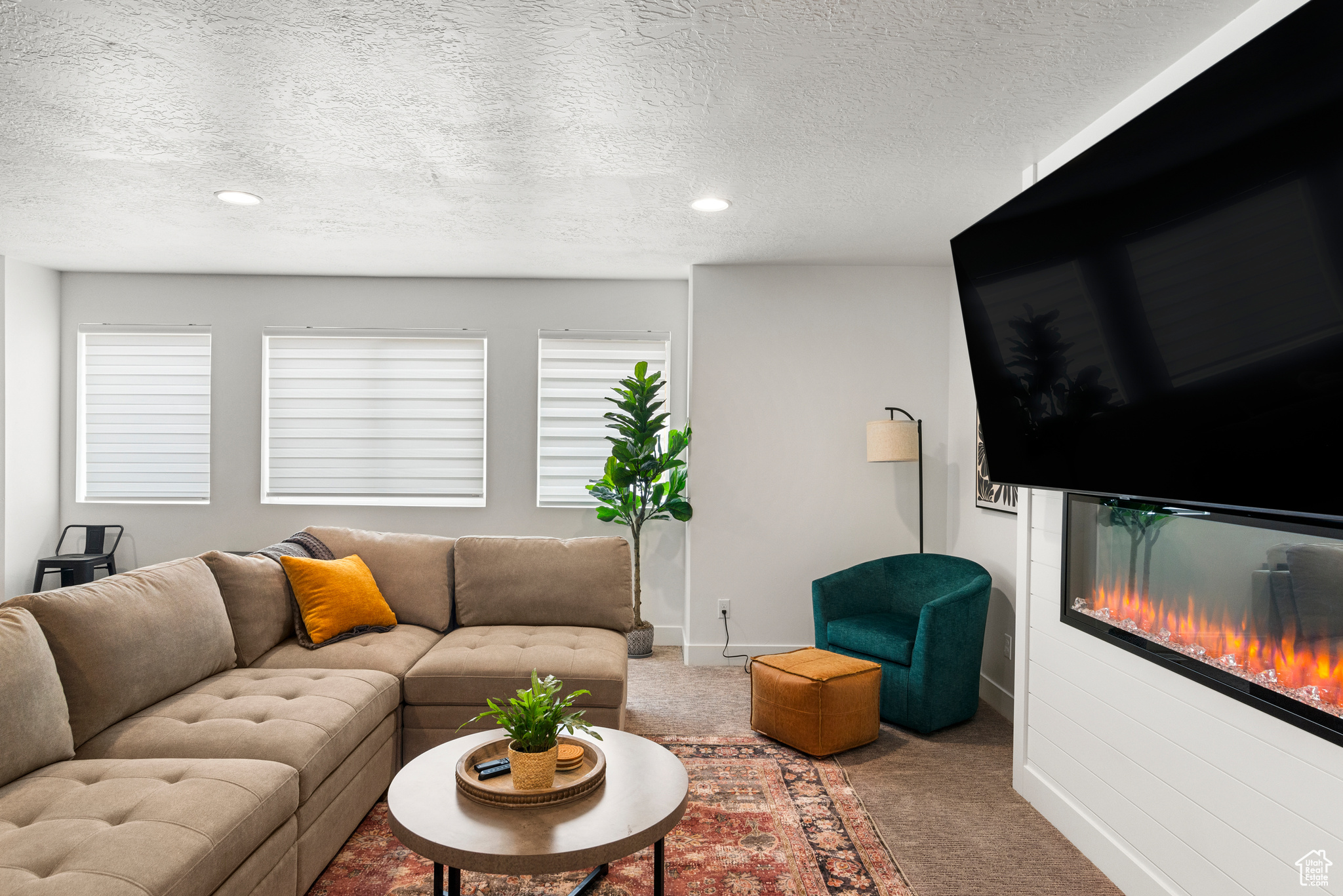 Carpeted living room featuring a healthy amount of sunlight and a textured ceiling