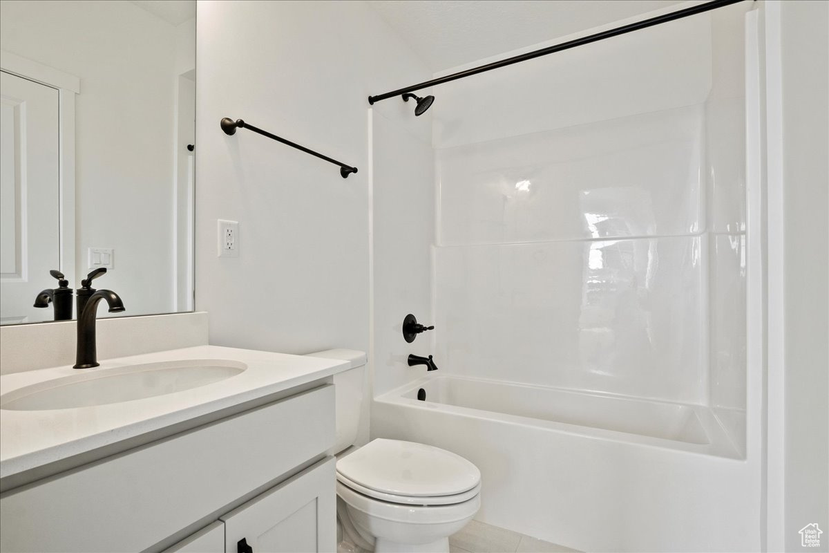 Full bathroom with bathtub / shower combination, vanity, and toilet