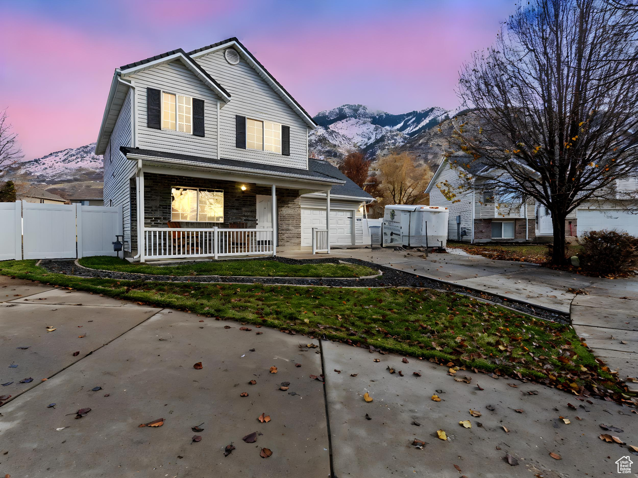 View of front of property featuring a lawn, a mountain view, a porch, and a garage