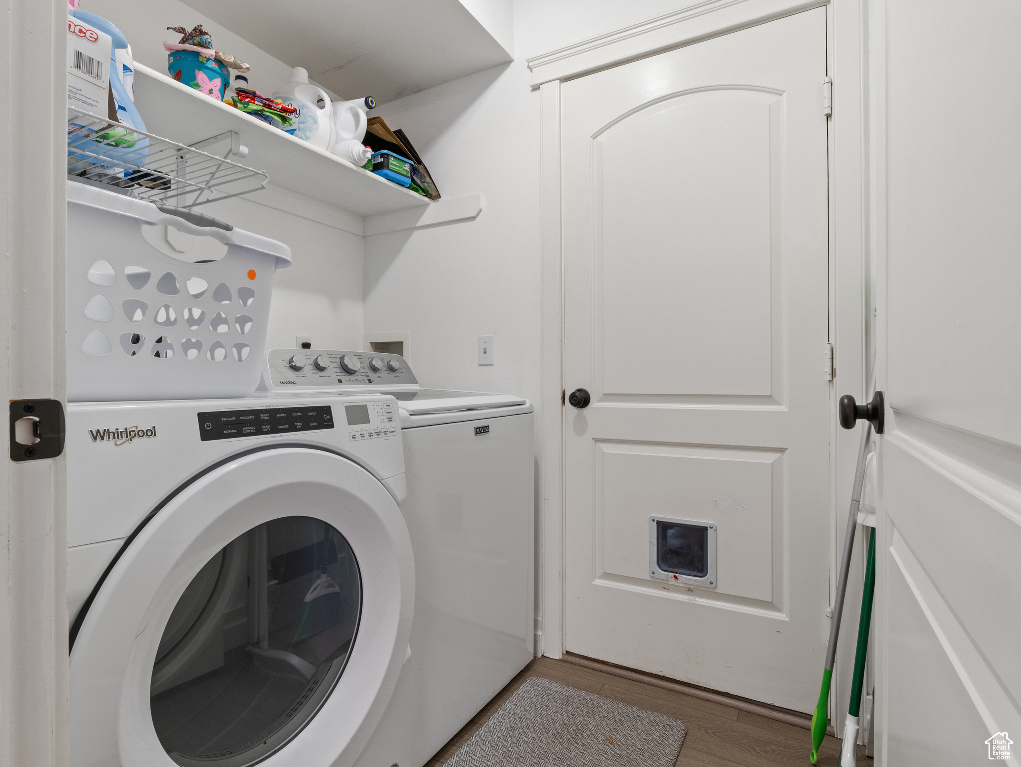 Laundry room with wood-type flooring and washing machine and clothes dryer