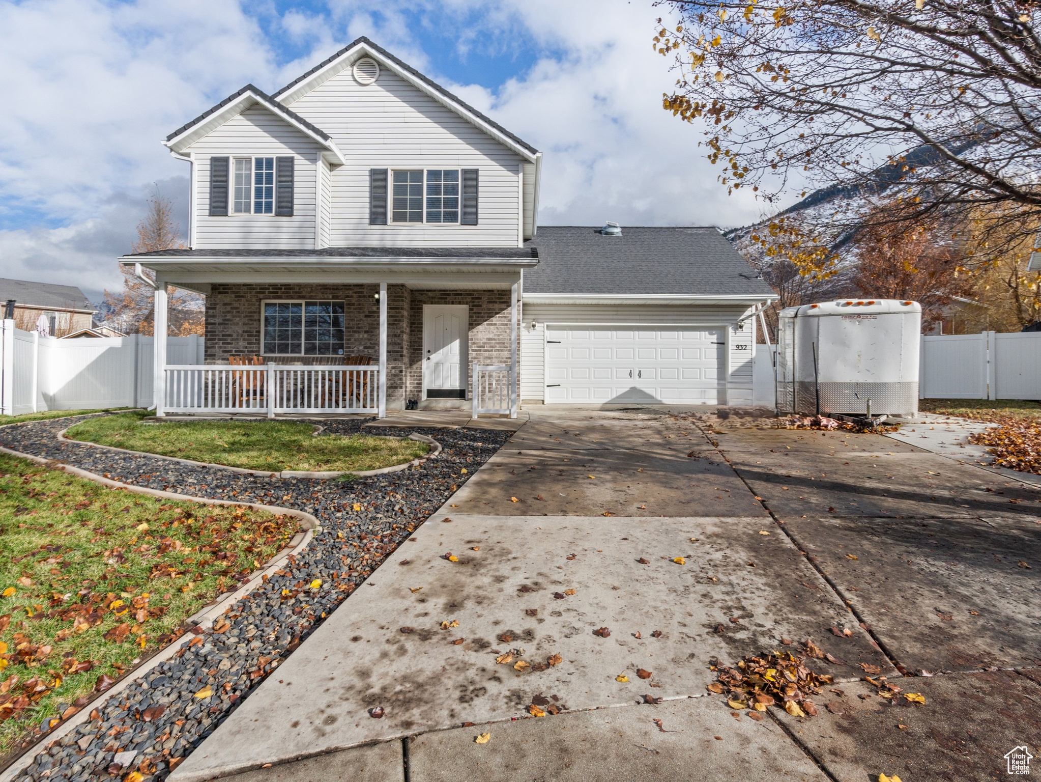 View of front of house featuring covered porch, a garage, and a front lawn