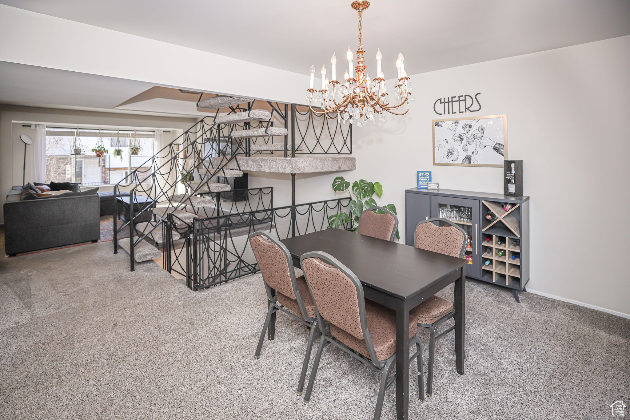 Dining area with carpet flooring and a notable chandelier