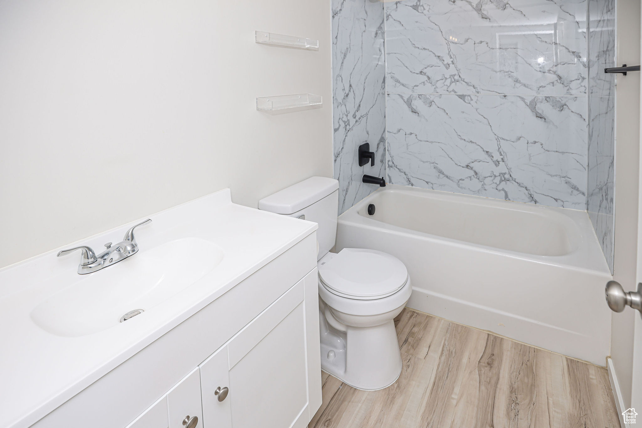 Full bathroom with vanity, hardwood / wood-style flooring, toilet, and shower / washtub combination