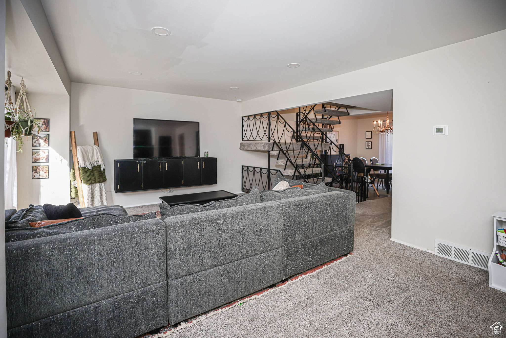 Carpeted living room featuring an inviting chandelier