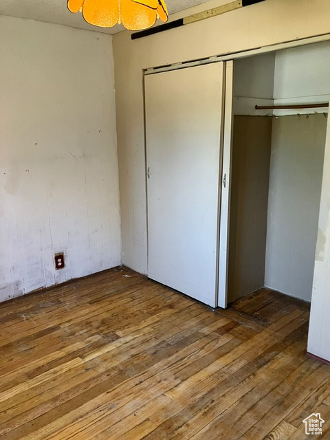 Unfurnished bedroom featuring wood-type flooring and a closet