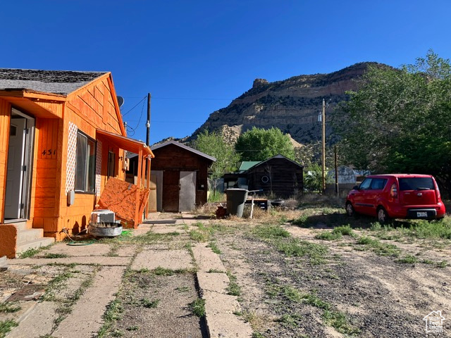 View of home's exterior with a mountain view and a storage unit