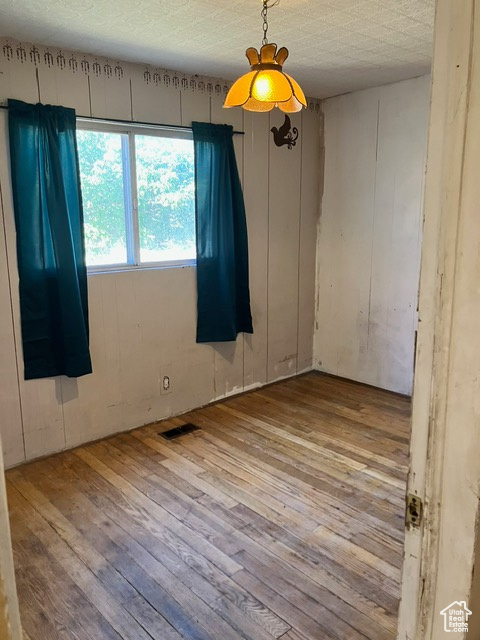 Unfurnished room with a textured ceiling and light wood-type flooring