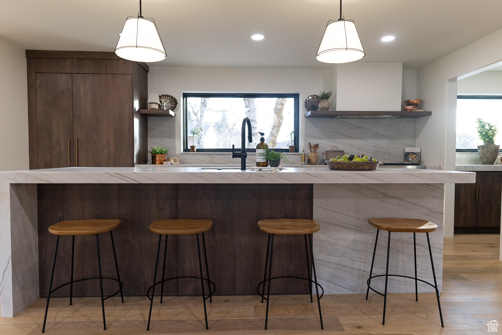 Kitchen with a kitchen breakfast bar, sink, a healthy amount of sunlight, and decorative light fixtures