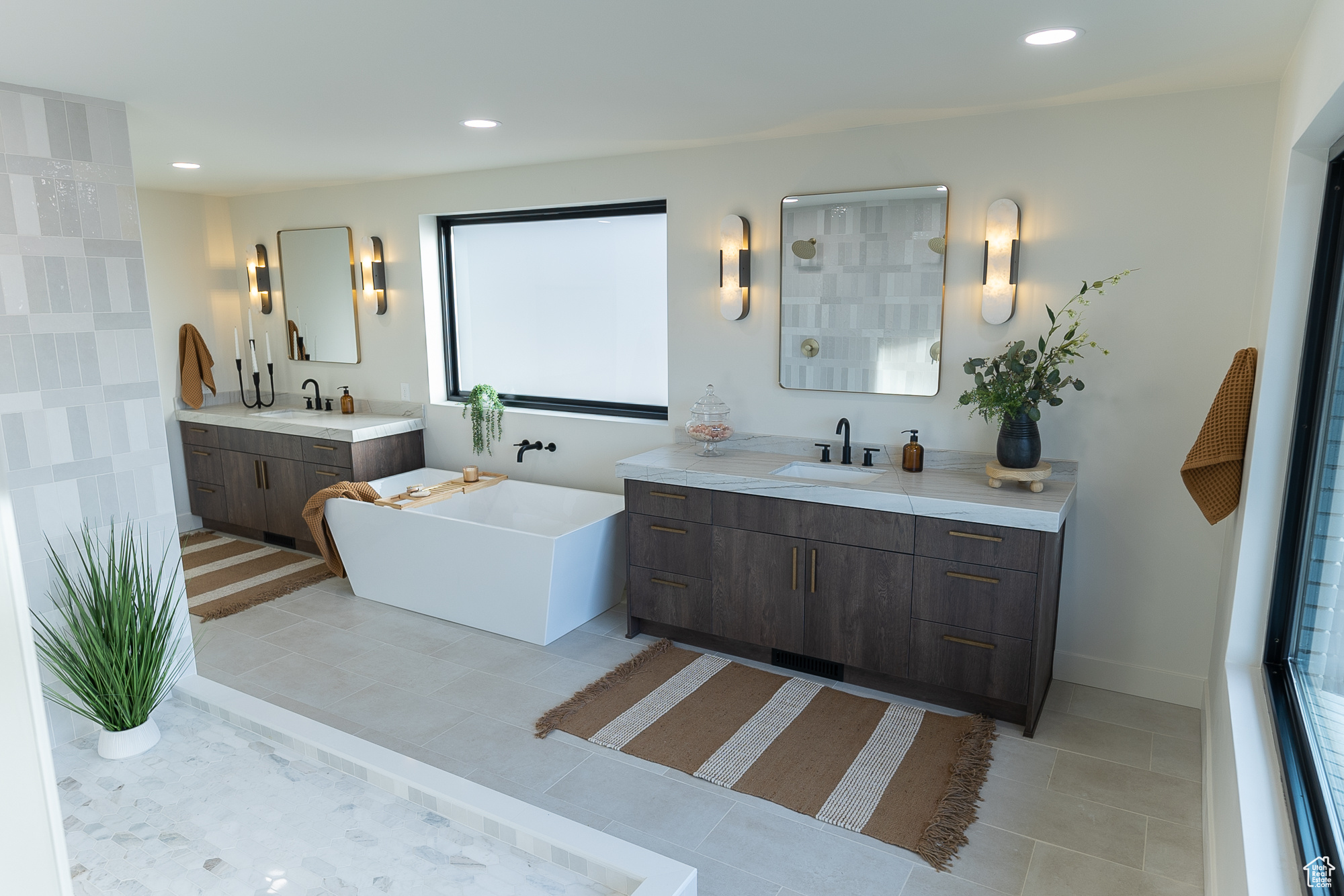 Bathroom with a bathtub, vanity, and tile patterned flooring