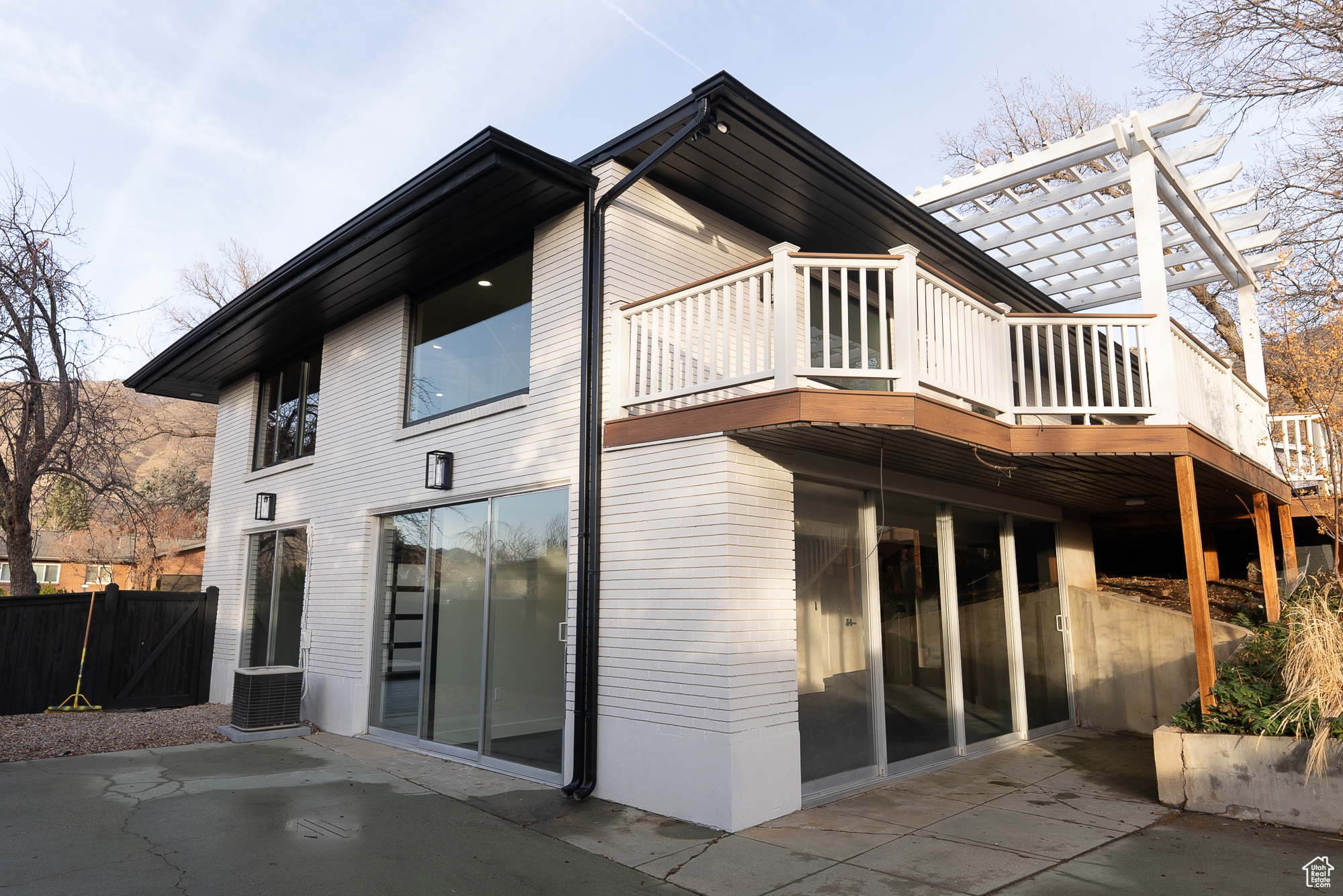 Rear view of property featuring cooling unit, a pergola, and a patio