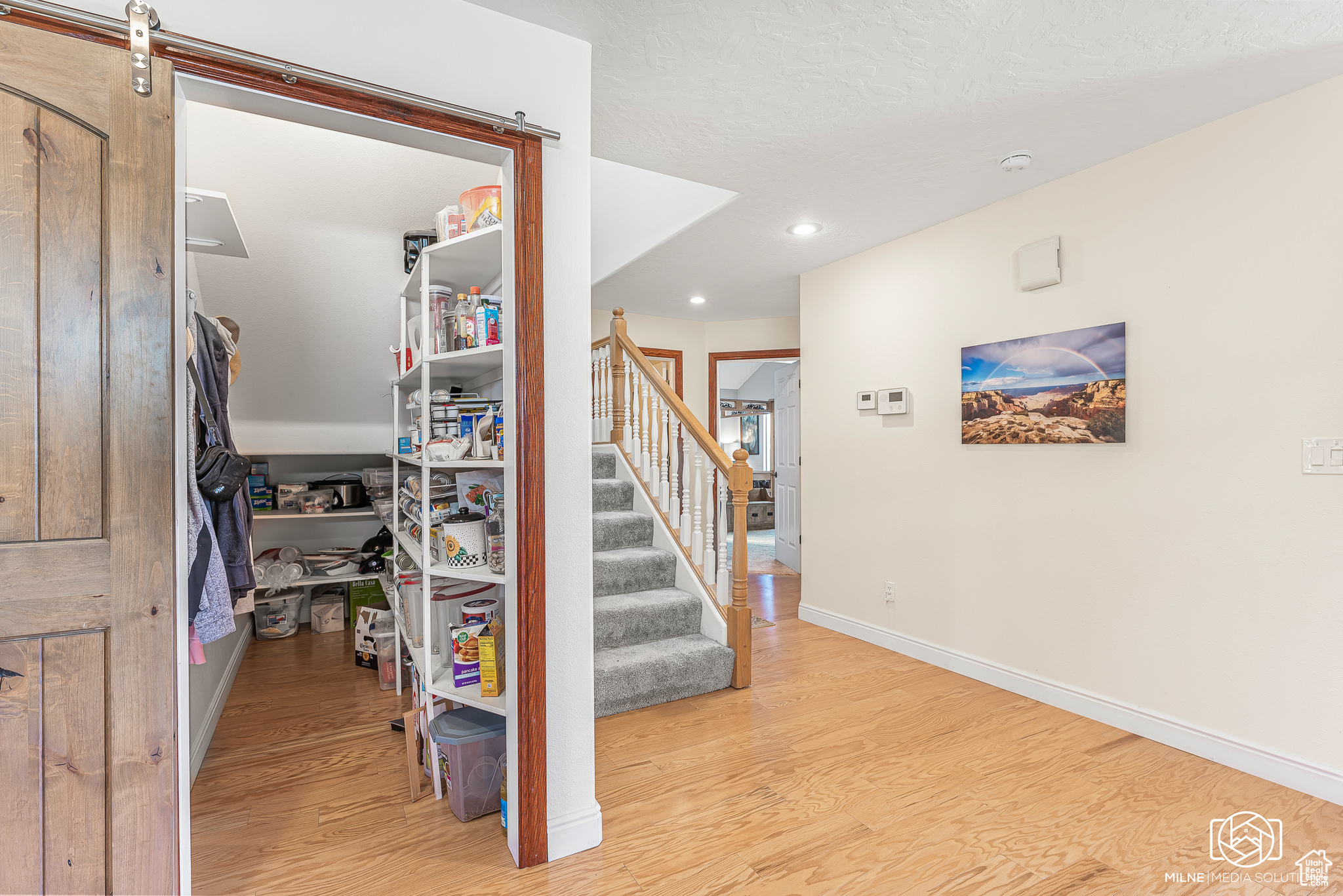 Staircase featuring hardwood / wood-style floors and a barn door