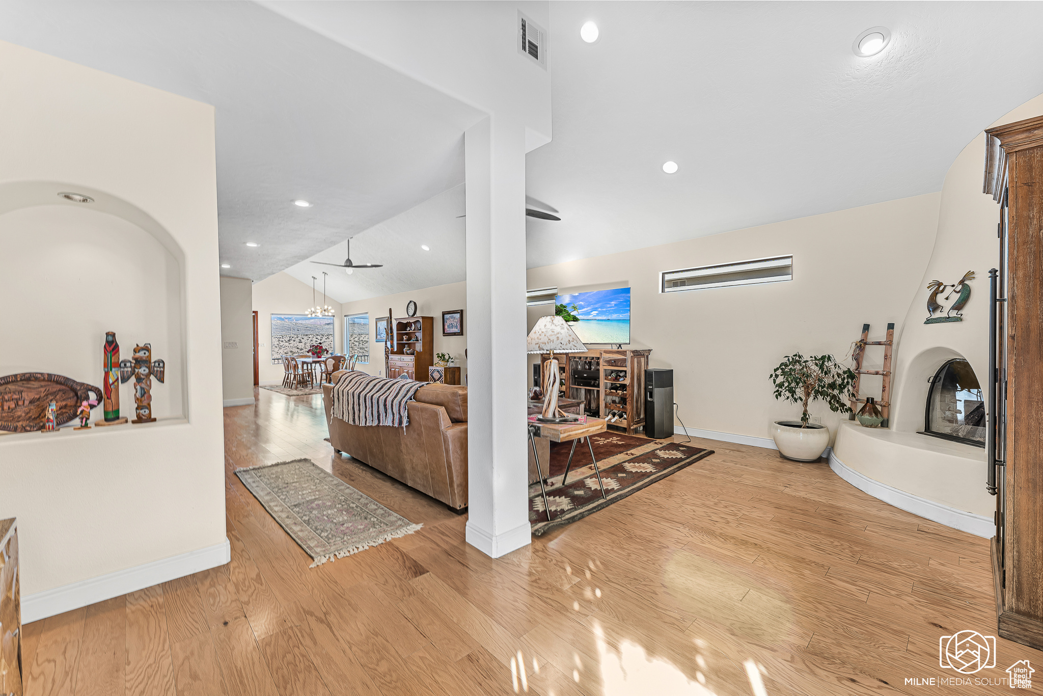 Living room featuring a wealth of natural light, vaulted ceiling, and light wood-type flooring